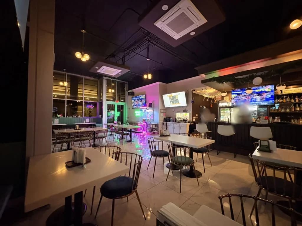 Aya Golf Lounge bar at Honolulu with five TVs above for live sports, ambient lighting, and lounge seating