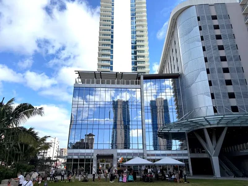 Crowds gather on the lawn at Midtown Eats grand opening celebration with DJ, games, and food tents at The Park on Keeaumoku